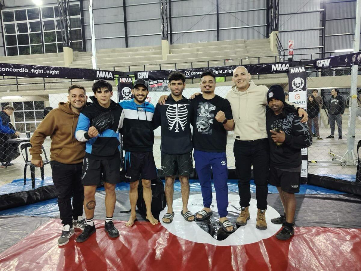 Equipo de Calavera Crew junto a la jaula de MMA en el Concordia Fight Night.