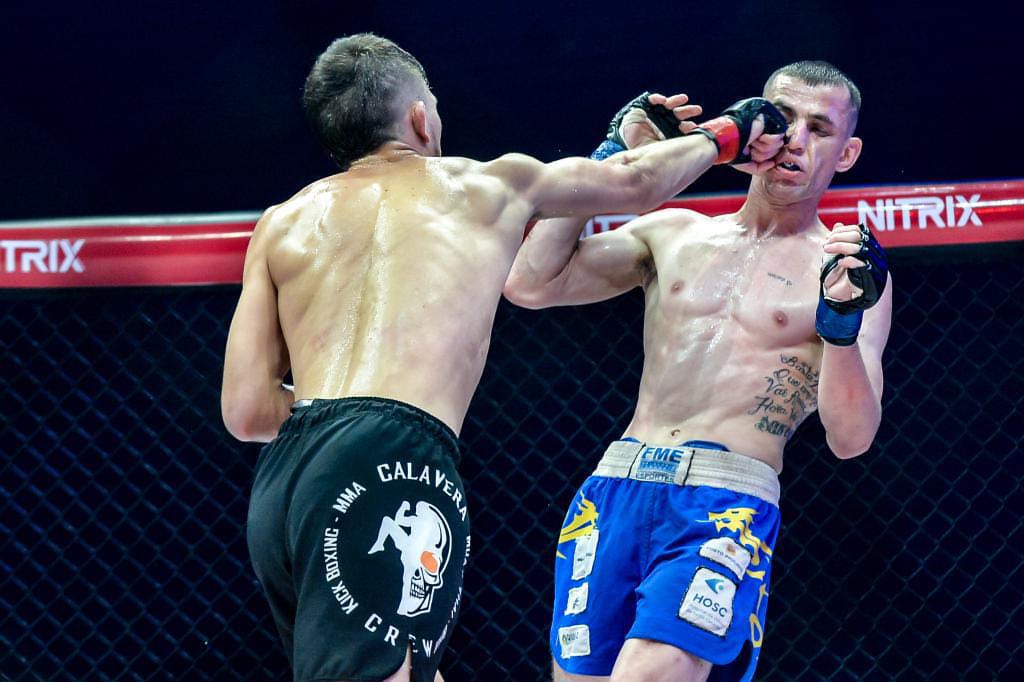 Peleador de Calavera Crew conectando un golpe en una pelea de MMA.